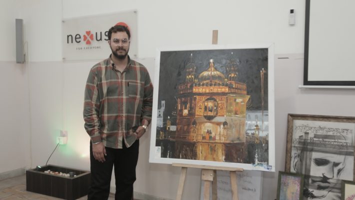 Person showing his painting at Unique Visual Art Exhibition